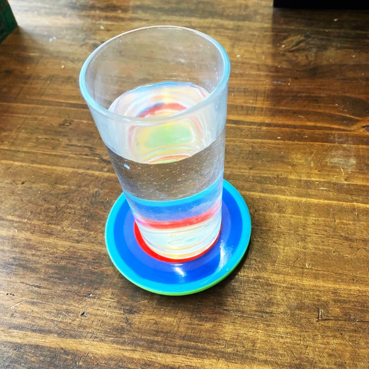 A glass on a Rainbow Coaster